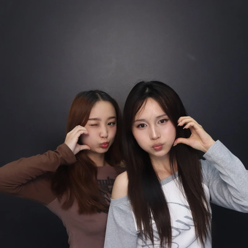 Two friends posing together in a photobooth